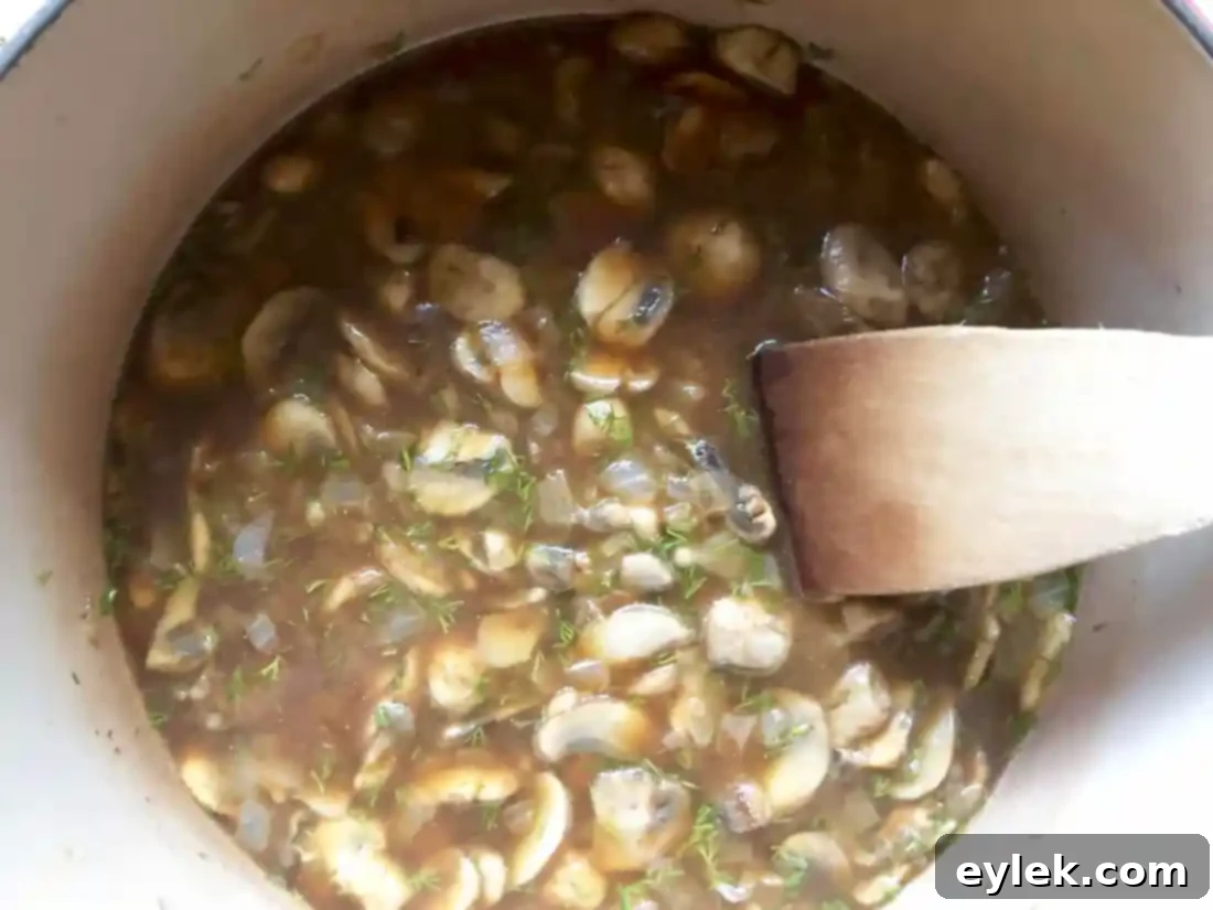 The soup still simmering, showing the depth of color from Hungarian paprika.
