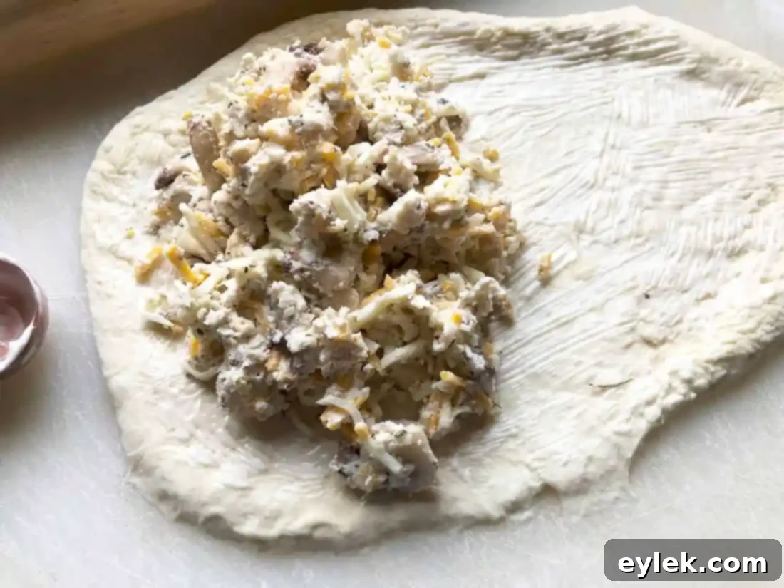 Calzone dough with mayonnaise spread on one half, ready for filling