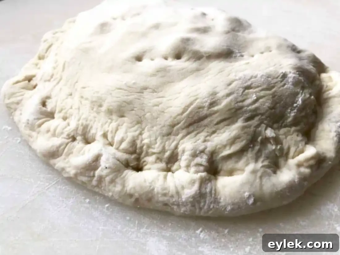 Half-moon shaped calzone with filling, ready to be sealed