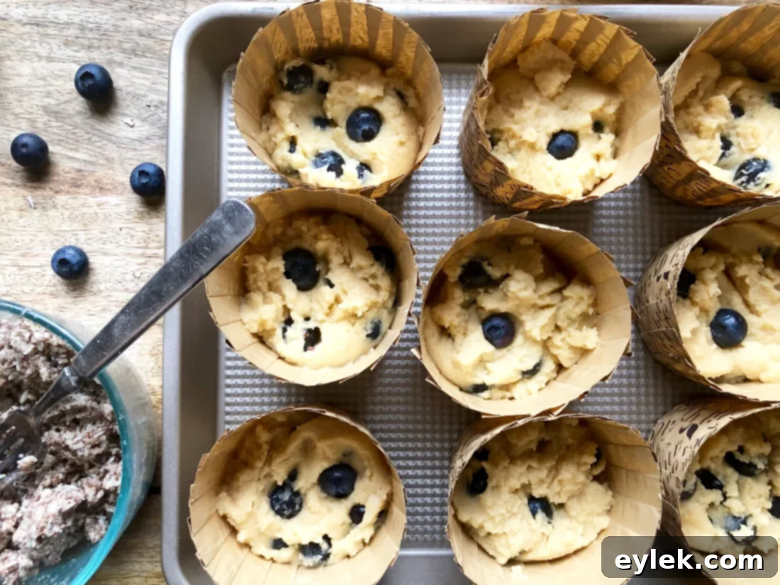 Muffin cups filled with batter and ready for crumb topping