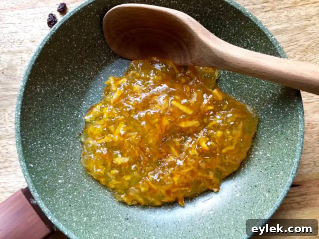 Warm marmalade being spread over the first layer of bread pudding