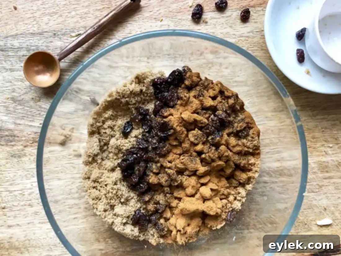 Raisin and cinnamon mixture evenly sprinkled over bread in a cake pan