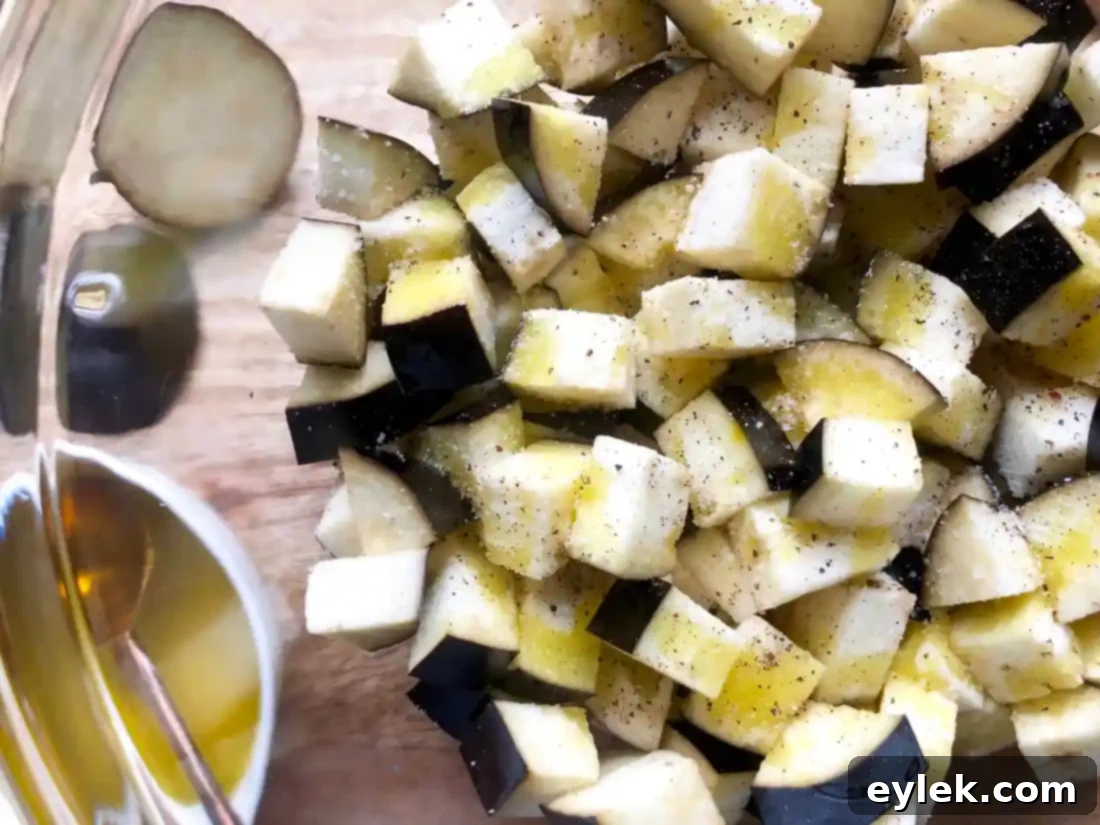 Eggplant cubes being tossed with tomato paste