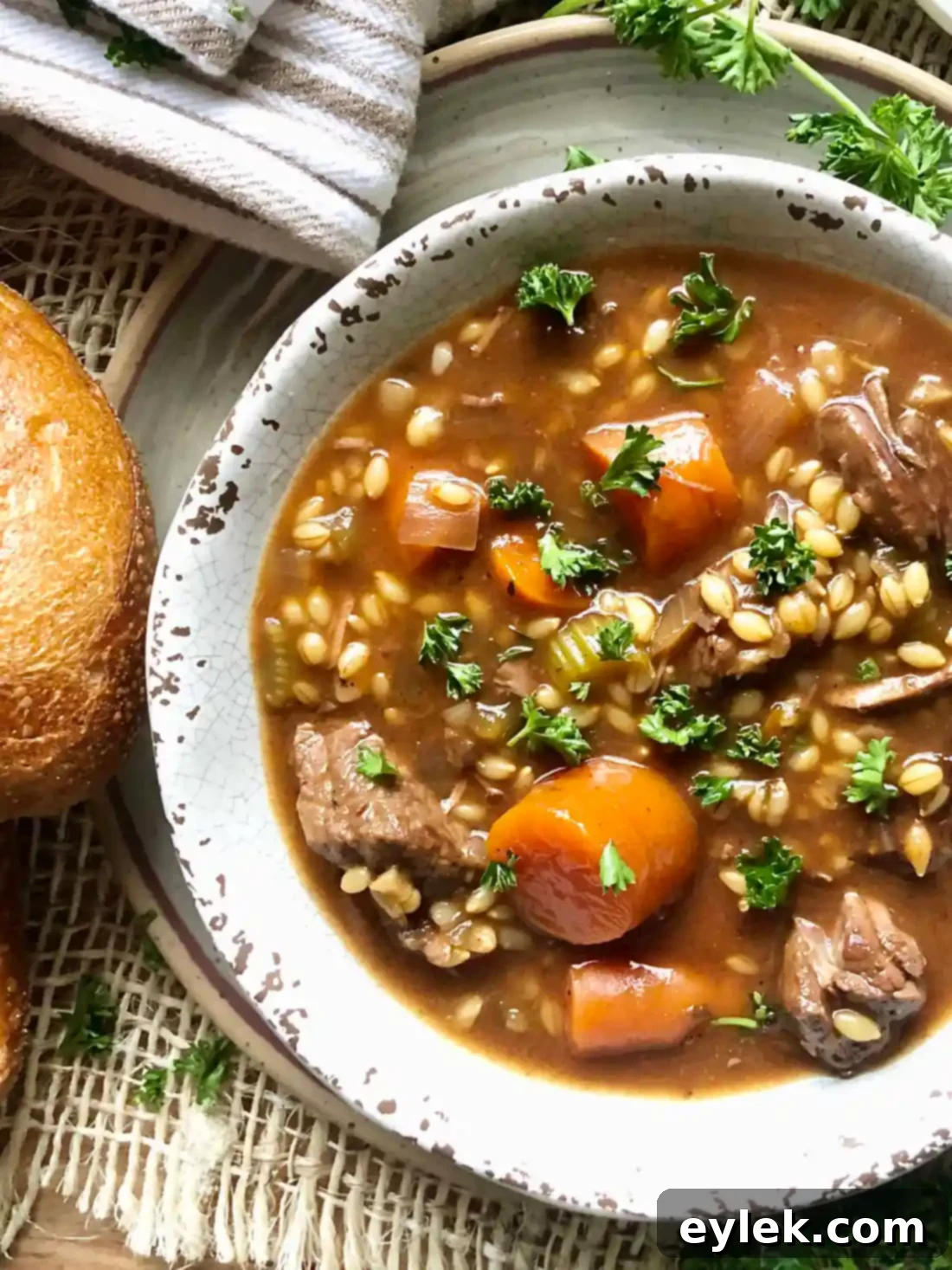 Slow Cooker Beef & Barley Stew served in a bowl with crusty bread
