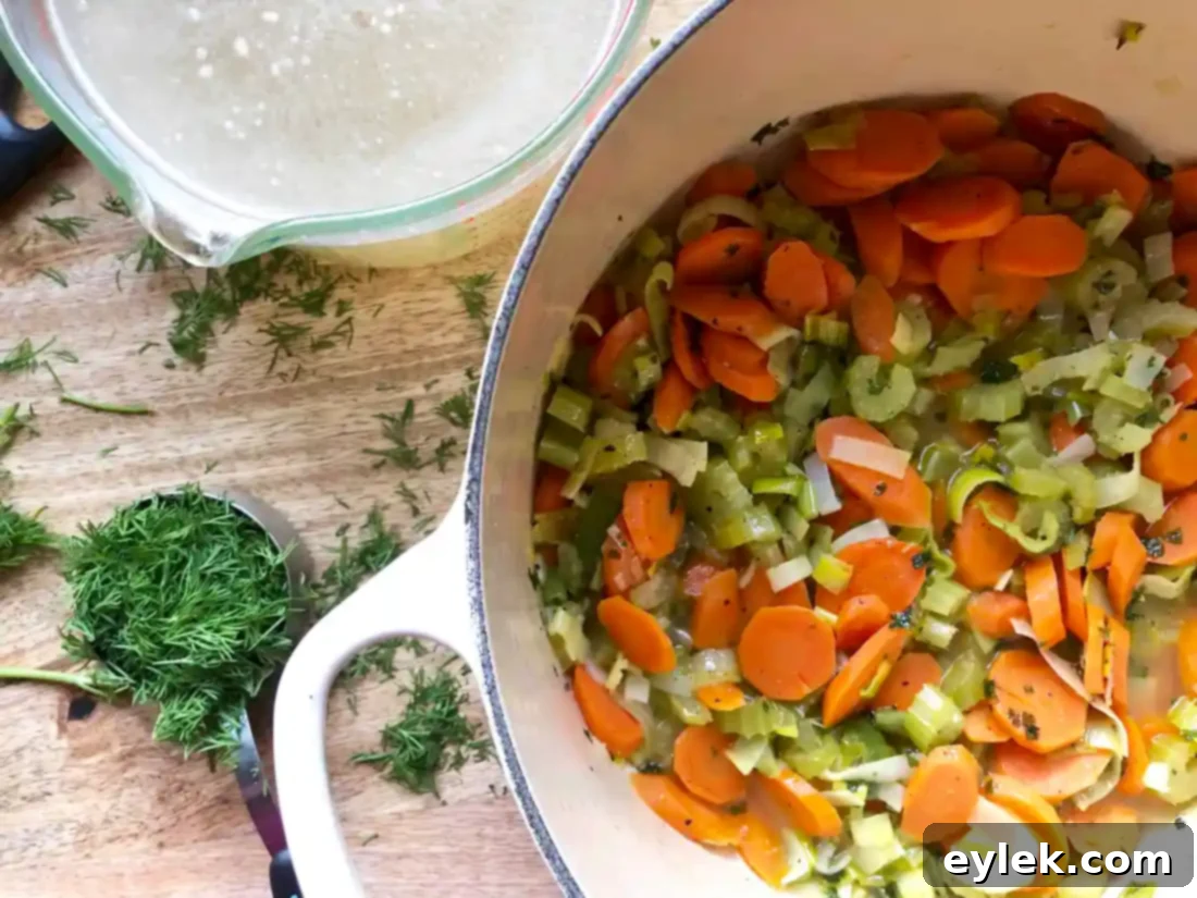 The soup broth beginning to boil with dill and vegetables.