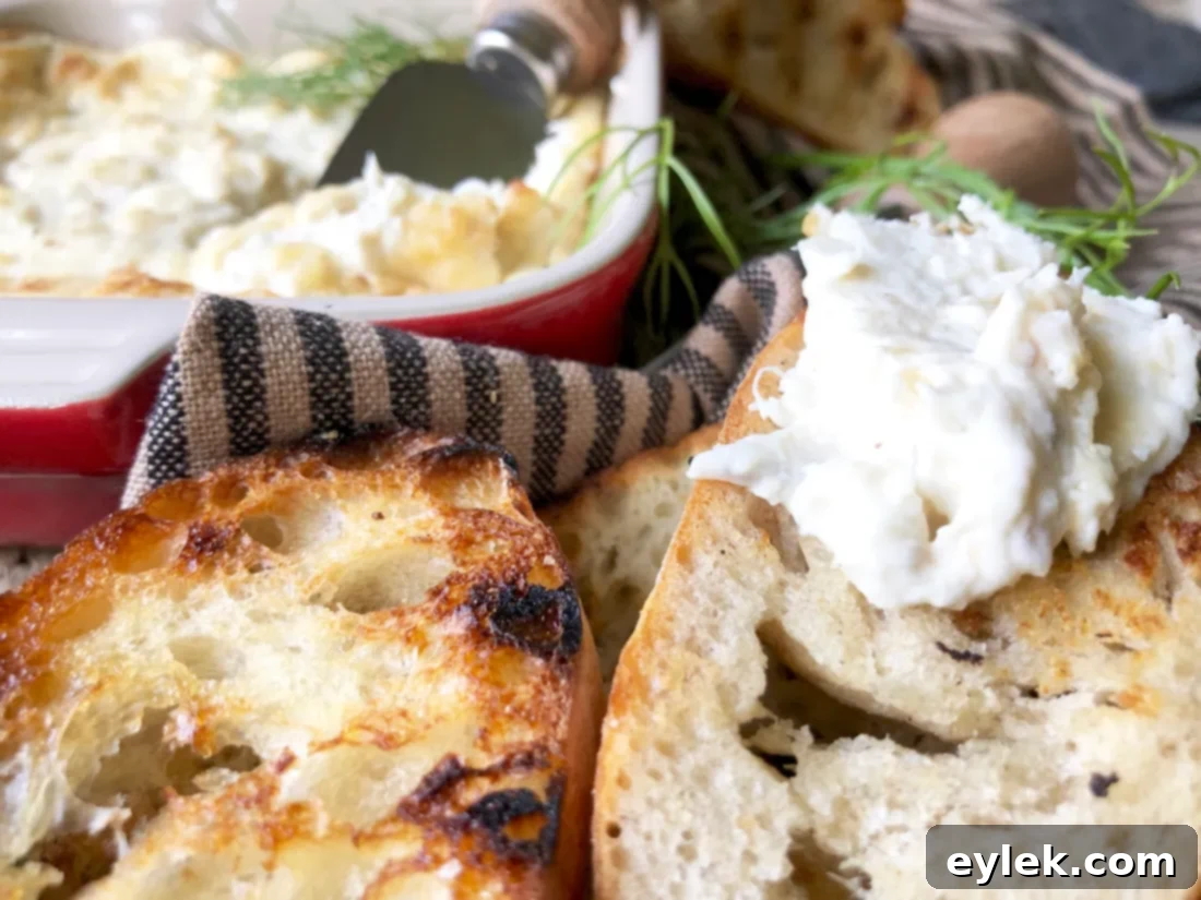 A close-up of the piping hot, baked crab dip with a spoon scooping a portion