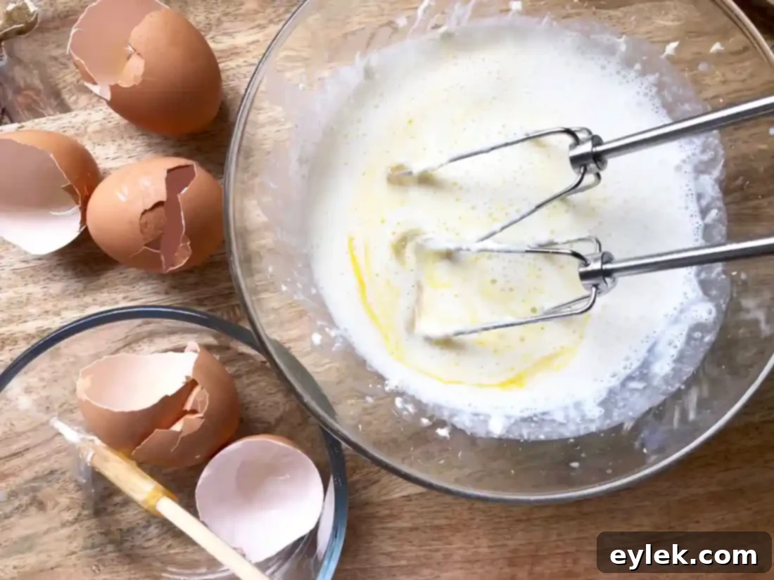 Adding milk and eggs to cream cheese