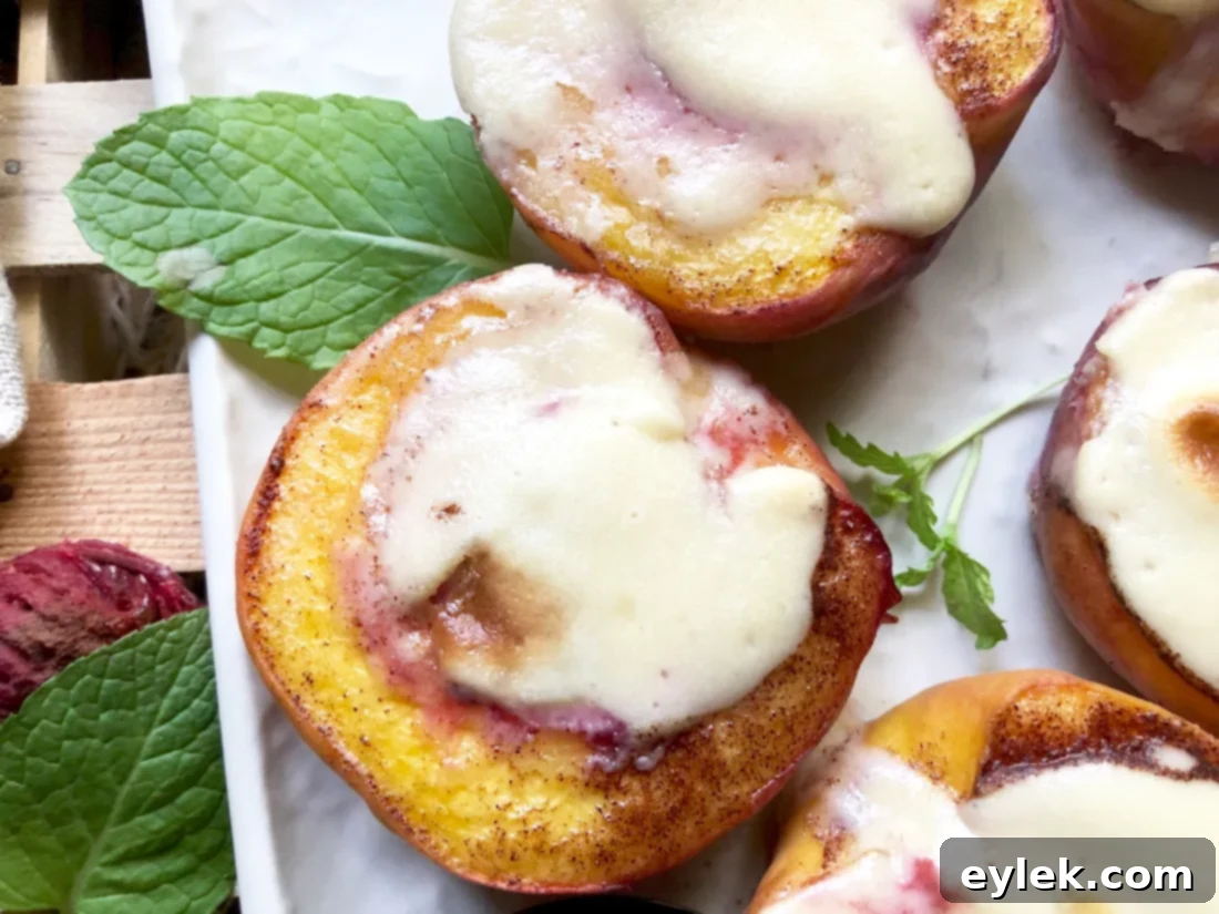 Two baked cheesecake-stuffed peach halves on a white plate