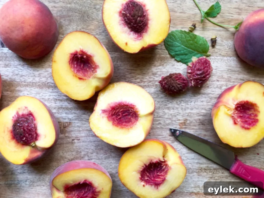 Close-up of fresh, halved freestone peaches arranged on a baking sheet