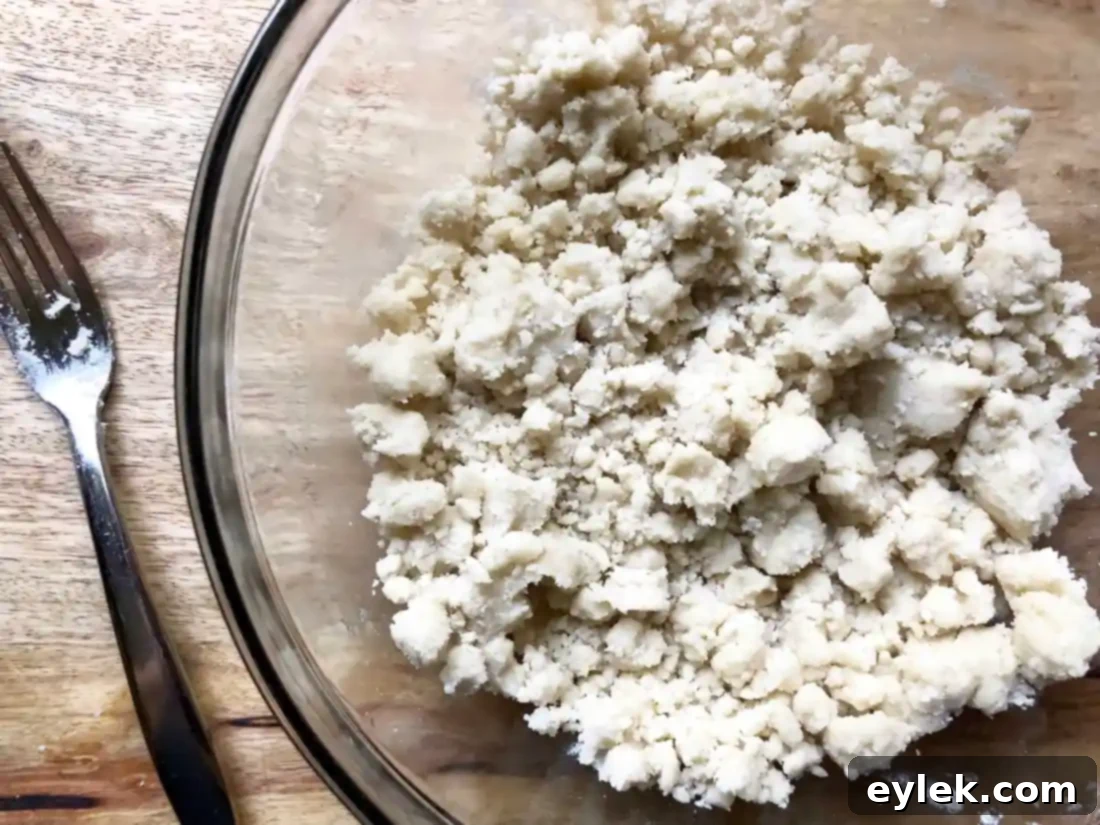 Raw tart crust being smoothed into the pan