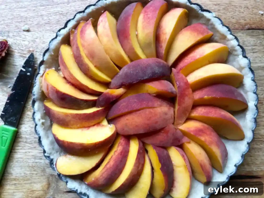 Close-up of fresh peach slices arranged on a tart crust