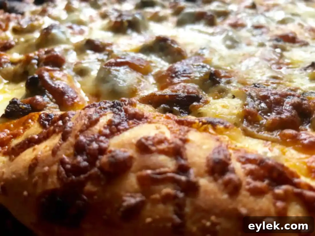 A pizza cutter slicing through a golden Mushroom Marsala Pizza.