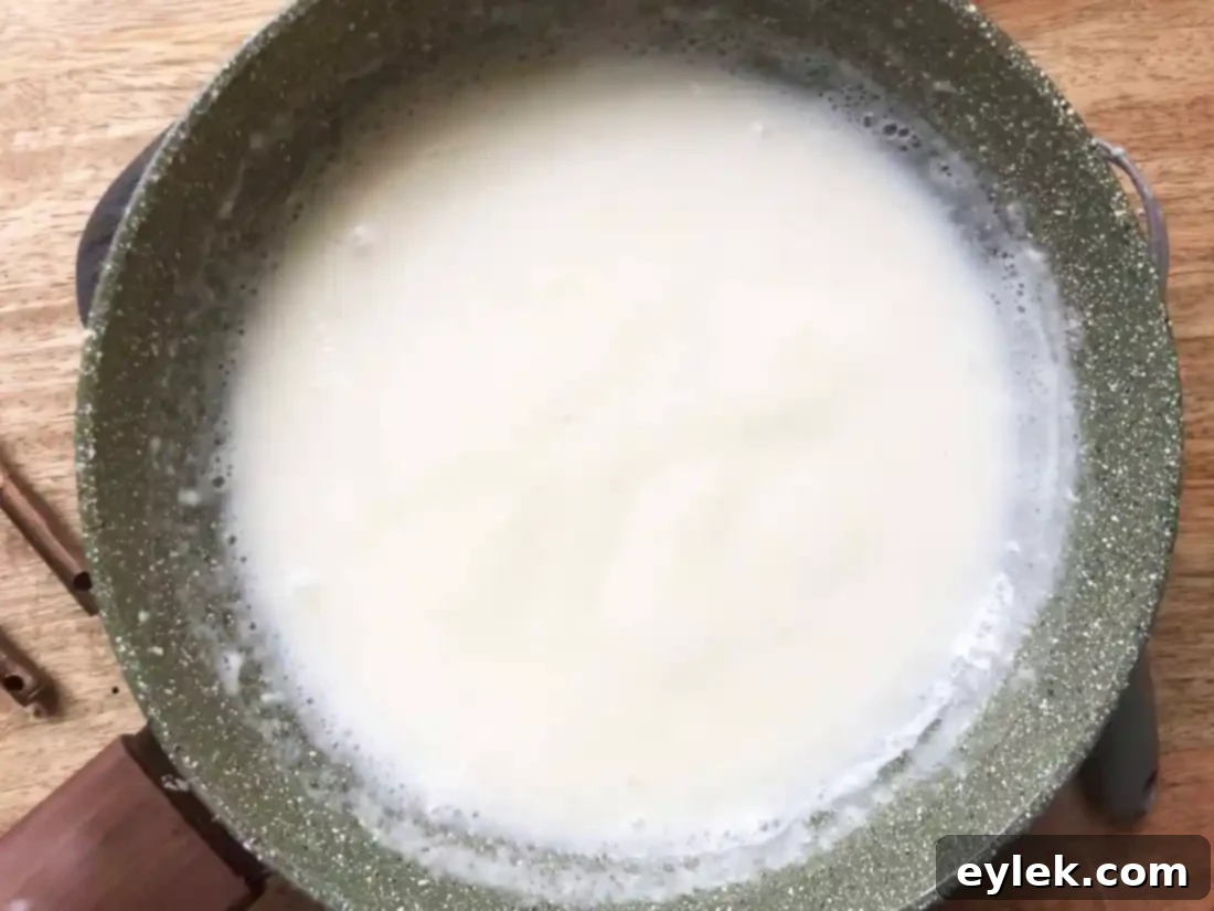 Thickened cheese sauce in a saucepan, ready for cheese.