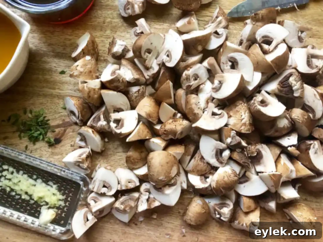 Quartered baby bella mushrooms in a bowl, ready for cooking.