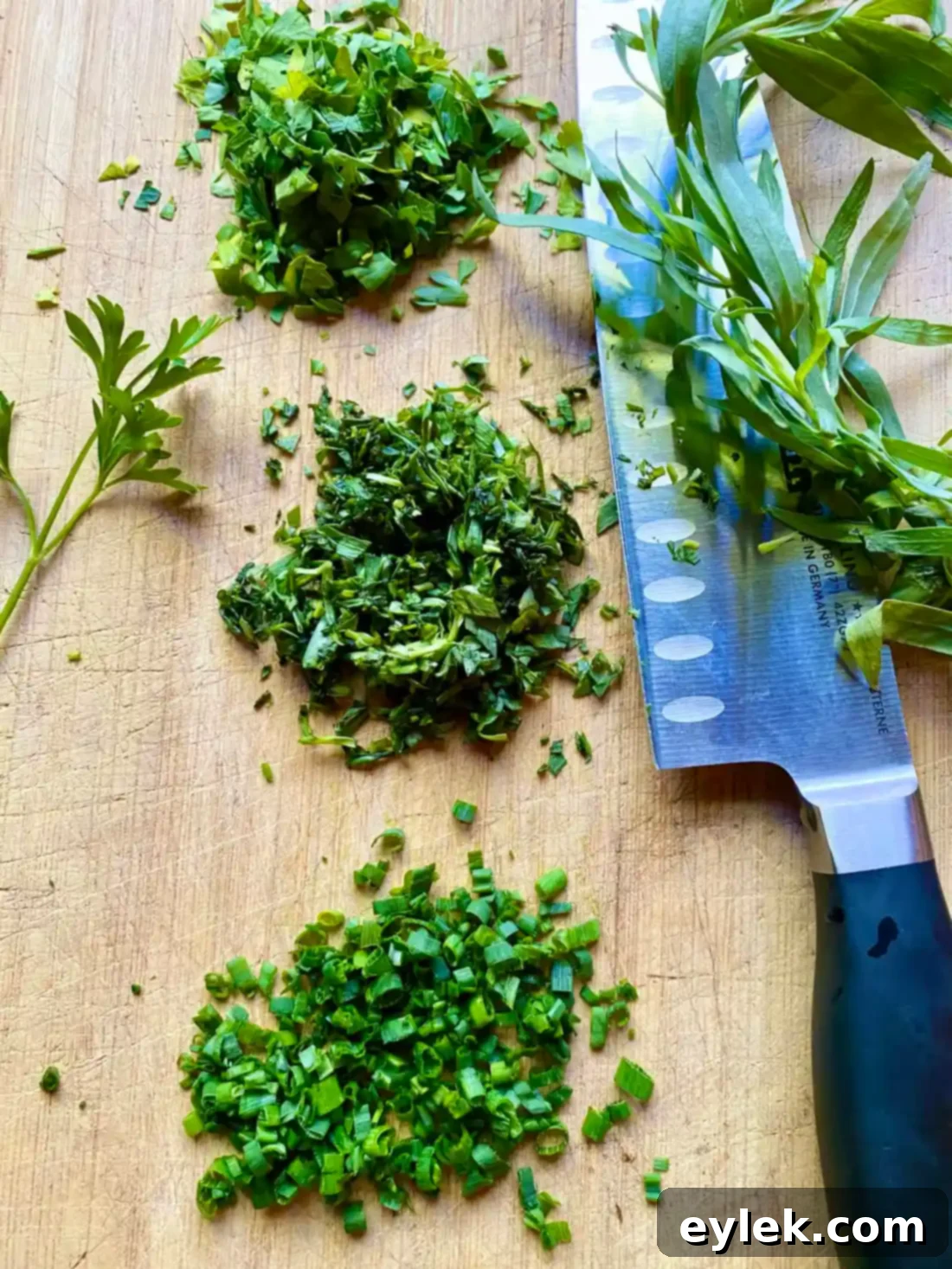 Adding finely chopped fresh herbs to the emulsified vinaigrette in a jar.